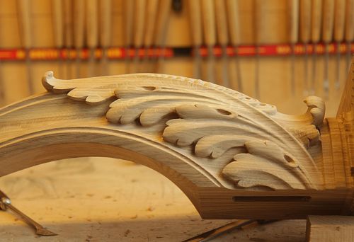 Hand Carving of Oak in Furniture Production, Decorative Element with an Elegant Floral Ornament on a Wooden Workpiece