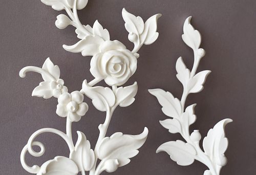 Polyurethane ceiling molding &mdash; white decorative branches with flowers and leaves against a gray ceiling