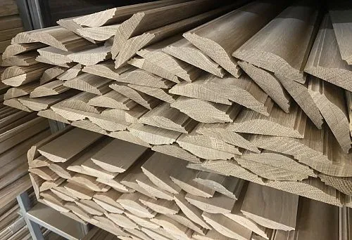 Wooden planks and battens for wall finishing, neatly arranged on metal shelves in a warehouse
