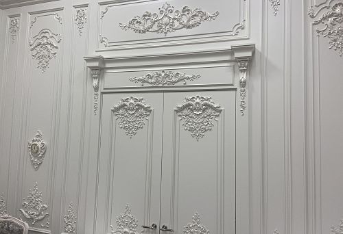 Snow-white decorative door frame molding with stucco decor and elegant ornaments in classic style