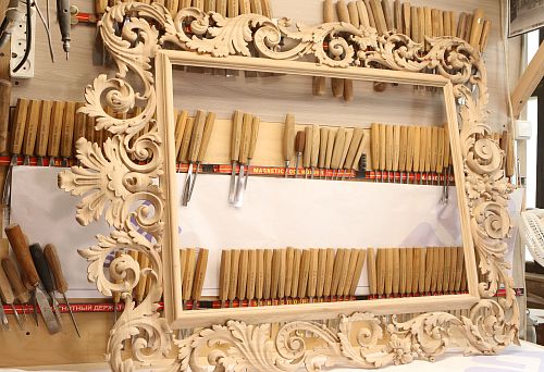 Large carved wooden unpainted frame with rich floral ornamentation