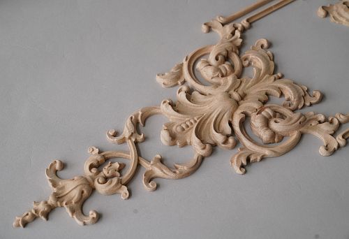 Close-up of a carved wooden element with complex shape, showcasing fine detailing