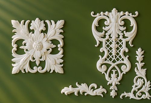 White Decorative Molding with Ornaments and Floral Patterns on Green Wall