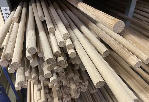 Round wooden dowels of various diameters neatly arranged on shelves in the warehouse
