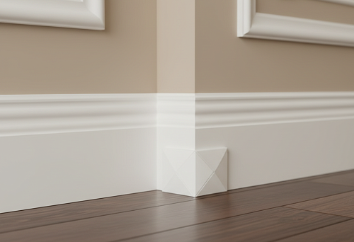 Neat baseboard corner finishing using polyurethane corner and wooden baseboard against decorative wall moldings