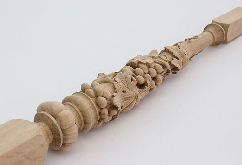 Decorative carved baluster from natural wood with grapevine ornament
