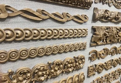 Various carved wooden profiles displayed on the stand, suitable for A4 document decoration