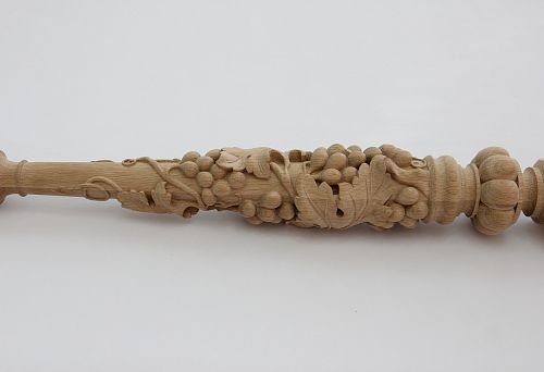Round carved baluster made of light wood with a three-dimensional grapevine pattern and large leaves, handcrafted.
