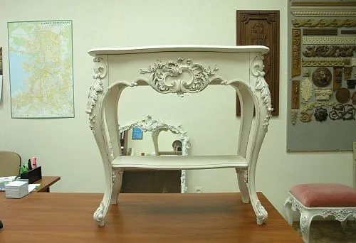 Elegant wooden table with gilded patterns and smooth lines.