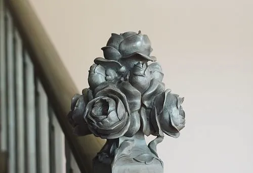 Decorative carving in the form of roses on the staircase handrail.