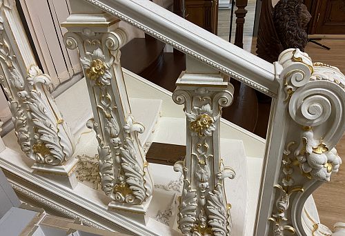 White balustrade with gold decorative elements and elegant carving