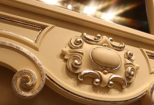 Decorative element from solid wood with carved pattern and finish