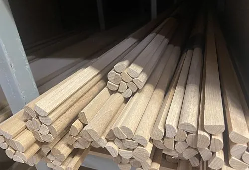 Round and semi-round wooden planks on the warehouse shelf, stacked on the shelf