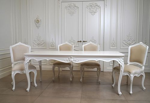 Elegant vintage-style chairs made of solid wood with soft upholstery against a light classic interior