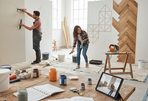 Мужчина наносит декоративную штукатурку на стену в процессе самостоятельного ремонта.