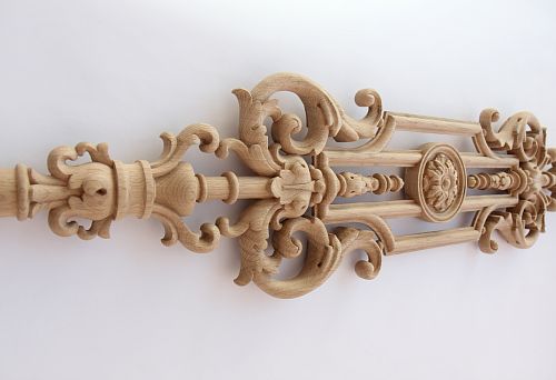 Detailed carved baluster element from natural wood on a white background