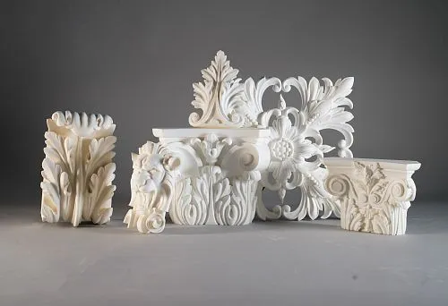 Composition of polyurethane decorative elements, including a rose, capitals with floral ornament, and a lion figurine