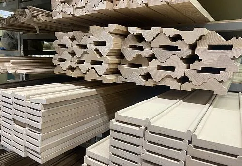 Carved and Smooth Wooden Rods, Piled on Shelves in the Warehouse &ndash; Solid Wood Products for Decorative and Technical Use