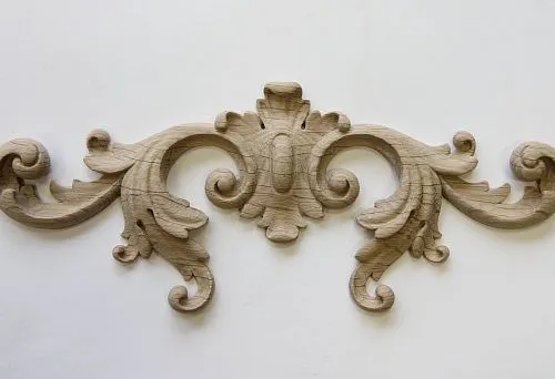 Carved wooden element with graceful curves, adorned with floral motifs.