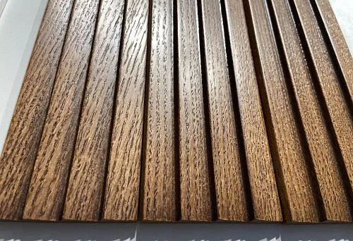 Close-up of a wooden baseboard plank in warm tone with pronounced natural wood grain texture.