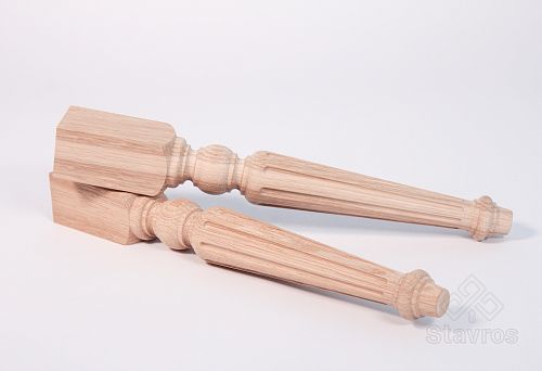 Two long carved wooden legs made of light wood, lying on a white surface.