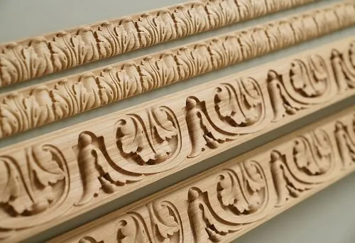 Set of carved wooden moldings with classic ornamentation, arranged in a row.