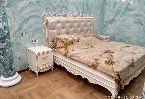 Роскошная спальня с резной кроватью и прикроватными тумбами