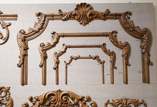 A set of carved wooden elements of various sizes, neatly arranged on a display stand.