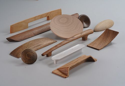 Various furniture hardware, including wooden handles and decorative elements for cabinets and furniture.