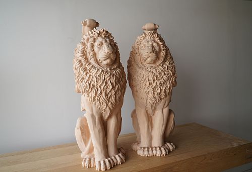 Pair of carved oak lions without finish on workbench &mdash; deep hand-carved work