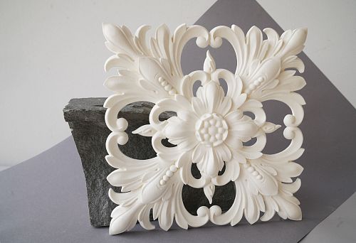 Polyurethane molding in the form of a rose under a chandelier on stone