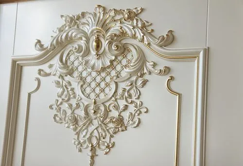 Elegant moldings with floral patterns and gold accents on a light surface.