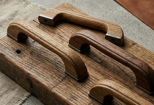 крупный план деревянных мебельных ручек с матовой текстурой на фоне грубой древесины