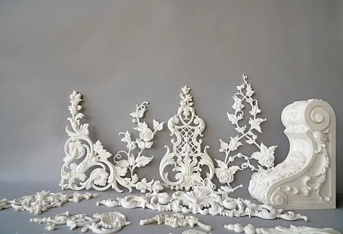 Set of decorative elements made of polyurethane: sockets, ornaments, and pilasters on a gray background