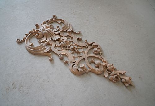 Carved decorative oak inlay with elegant scrolls, lattice ornament, and floral elements