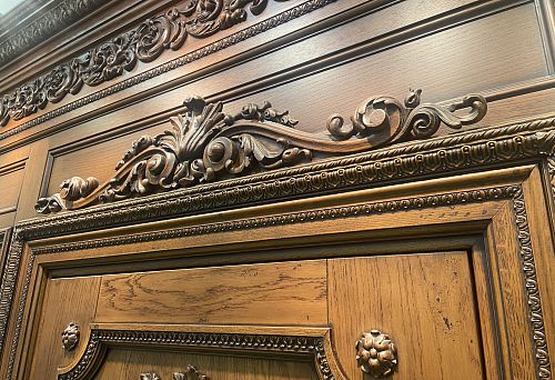 Sandro in architectural decoration above a wooden door frame