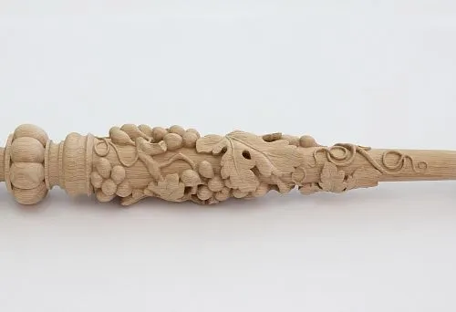 Carved baluster from light wood with a three-dimensional floral pattern and grape clusters