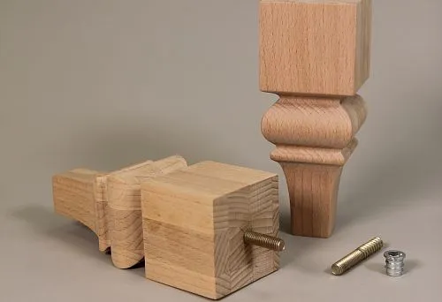 Wooden furniture legs with mounting hardware for installation on a set.