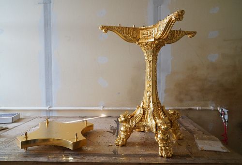 Gilded carved leg of a vintage table with decorative griffin motifs