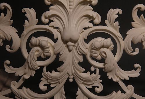 Three-dimensional molded relief in light tone with curved lines and floral elements