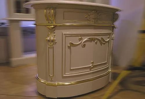 Luxurious wooden furniture with carved decoration and gold finish.