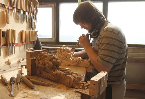 Craftsman at work carving wood in a furniture workshop