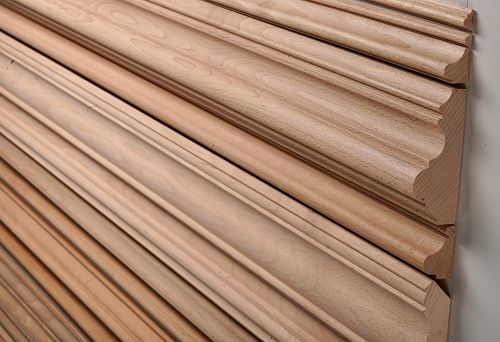 Smoothly finished wooden slats, including samples with round cross-section, laid out in a row