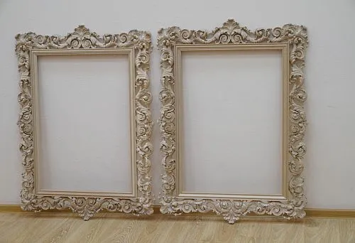 Two large carved wooden frames with rich ornamentation, mounted on the wall.