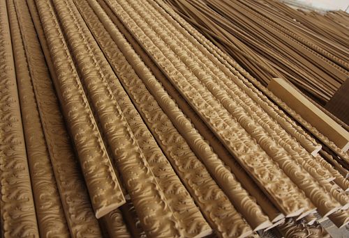 Multiple carved wooden poles arranged in rows, with detailed patterns and neat finishing.