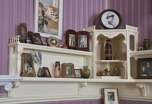 Elegant Carved Shelves with Vintage Vases and Family Photographs.
