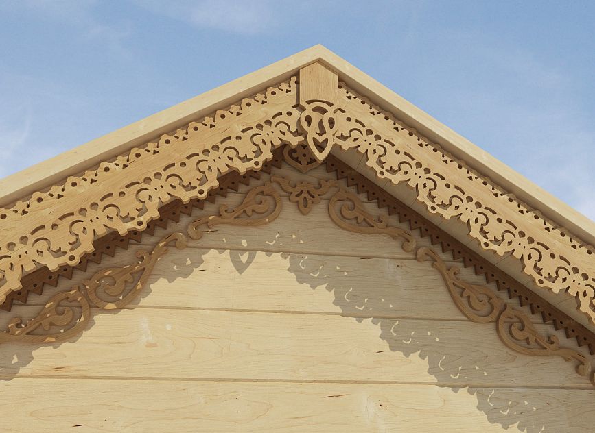 Decorative wooden gable of a house with carved elements.