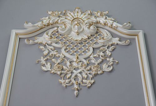 Classic white molding with gold trim and relief floral ornament on walls and ceilings.