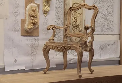 Carved wooden frame of a classic armchair in the restoration process.